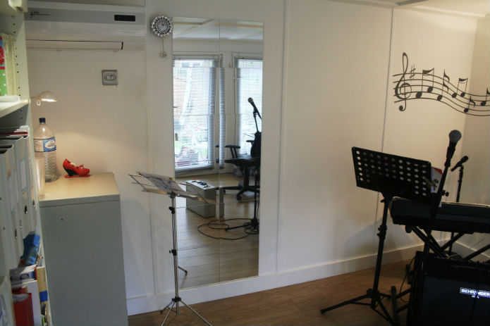 Singing teacher with mirror for her pupils in a garden office