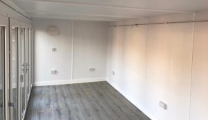 interior of garden office showing light track, sockets and grey flooring